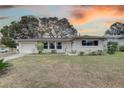 Charming ranch home with well-manicured lawn and sunset view at 553 Lake Hill Ln, Largo, FL 33771