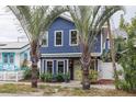 Two-story blue house with white trim, landscaping, and palm trees at 605 7Th N St, St Petersburg, FL 33701