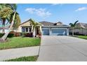 Inviting single-Gathering home with well-maintained lawn, mature palm trees, and a spacious driveway leading to the garage at 6645 Current Dr, Apollo Beach, FL 33572