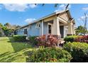 Side view of a well-maintained house with a manicured garden, privacy fence, and a spacious driveway at 6645 Current Dr, Apollo Beach, FL 33572