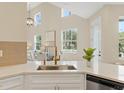 Kitchen features white cabinets, quartz counters, and a gold faucet at 7798 93Rd N St # 1, Seminole, FL 33777