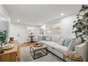 Bright and airy living room with light gray sectional sofa and wood flooring at 803 E North St, Tampa, FL 33604