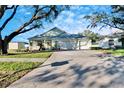 Front view of a light green house with a two-car garage at 803 Innergary Pl, Valrico, FL 33594