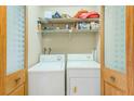 Condo laundry room with washer, dryer, and ample shelving for storage at 90 S Highland Ave # 7, Tarpon Springs, FL 34689