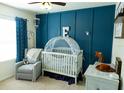 Bright Bedroom featuring a crib, accent wall, and soft color scheme at 10029 Warm Stone St, Thonotosassa, FL 33592