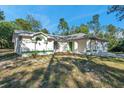 White house with green trim, attached garage, and grassy yard at 12240 Eakin St, Weeki Wachee, FL 34614