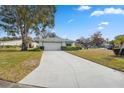 Home's front facade with a long driveway at 13000 Club Dr, Hudson, FL 34667