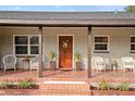 Inviting front porch with tiled floor and wicker chairs at 1338 Whitacre Dr, Clearwater, FL 33764