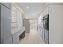 Long galley kitchen with granite countertops and gray cabinets at 1338 Whitacre Dr, Clearwater, FL 33764