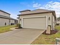 Tan colored two-car garage with a paved driveway at 1575 N River Cir, Tarpon Springs, FL 34689