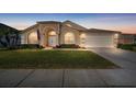 Tan house with arched entryway, American flag, and manicured lawn at 2102 Golf Manor Blvd, Valrico, FL 33596