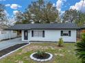 Newly renovated ranch home, featuring a white brick exterior and updated landscaping at 2104 W Okaloosa Ave, Tampa, FL 33604