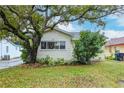 Cute bungalow style home with a large tree in the front yard at 310 W Hilda St, Tampa, FL 33603