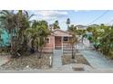 Quaint beachfront cottage features a pink exterior, white picket fence, and a lovely front yard at 342 Boca Ciega Dr, Madeira Beach, FL 33708