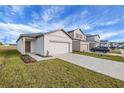 New construction home with a two-car garage and a nicely landscaped front yard at 35605 Buttonweed Trl, Zephyrhills, FL 33541