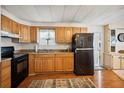 Kitchen with wood cabinets, black appliances, and a view of the backyard at 5149 Jo St, Zephyrhills, FL 33542