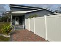 Gray house with white fence and brick paver walkway at 7336 Orchard Dr, Wesley Chapel, FL 33545