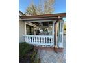 Covered front porch with white columns, copper gutters, and brick pavers at 8006 N Rome Ave, Tampa, FL 33604