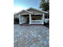 Front porch with white balustrade, brick pavers, and double doors at 8006 N Rome Ave, Tampa, FL 33604