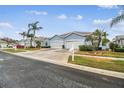 Street view of multiple light blue houses with two-car garages at 11447 Golf Round Dr, New Port Richey, FL 34654