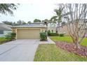 Two-story house with a tan exterior, two-car garage, and manicured lawn at 12127 Luftburrow Ln, Hudson, FL 34669