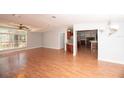 Bright living room featuring wood-look floors, a ceiling fan, and a large window at 1236 Live Oak Ln, Lutz, FL 33558