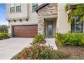 Two-story home with a wood garage door and stone accents at 14690 Horse Trot Rd, Lithia, FL 33547