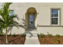 Front entrance with arched doorway and gray door at 1740 W Saint Louis St, Tampa, FL 33607