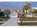 Tan house with white garage door and palm tree at 17436 Lawn Orchid Loop, Land O Lakes, FL 34638