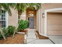 Inviting front entryway with a gray door and landscaping at 19144 Meadow Pine Dr, Tampa, FL 33647