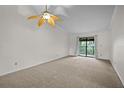 Bright bedroom features a ceiling fan and sliding glass door to the outdoor balcony at 2375 Lake Heather Heights Ct # 202, Dunedin, FL 34698