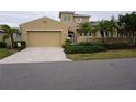 Tan two-story house with a three-car garage and landscaped yard at 2431 Kensington Greens Dr # 0, Sun City Center, FL 33573