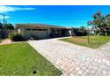 Single story home with a large brick paver driveway at 3182 65Th N St, St Petersburg, FL 33710