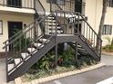 Exterior condo building stairwell with metal railings and landscaping at 391 Airport E Ave # 403, Venice, FL 34285