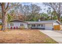 Gray Ranch home with a blue front door and mature landscaping at 7000 Dr Martin Luther King Jr S St, St Petersburg, FL 33705