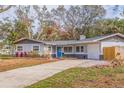 Charming ranch home with gray exterior, blue door, and landscaped yard at 7000 Dr Martin Luther King Jr S St, St Petersburg, FL 33705