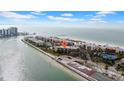 Aerial view highlighting condo building's location near beach and tennis courts at 7537 Bayshore Dr # 406, Treasure Island, FL 33706