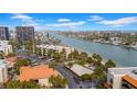 Aerial view showing condo building, waterfront, and nearby amenities at 7537 Bayshore Dr # 406, Treasure Island, FL 33706