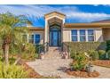 Inviting home exterior featuring a tiled walkway and lush landscaping at 127 Sands Point Dr, Tierra Verde, FL 33715