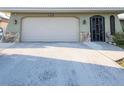 View of the attached garage with a large driveway at 1290 Cambridge Dr, Venice, FL 34293