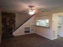 Living room features a stone fireplace, built-in shelving, and staircase at 1820 Bough Ave # 3, Clearwater, FL 33760