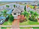 Two-story house with lake views, brick driveway, and landscaping at 18865 Deer Tracks Loop, Lutz, FL 33558