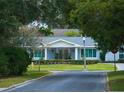 Gray brick house with lush landscaping and a tree-lined street at 301 Osceola Rd, Belleair, FL 33756