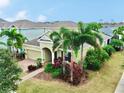 Two-story house with a light beige exterior, brick driveway, and palm trees at 5230 Admiral Pointe Dr, Apollo Beach, FL 33572