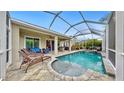 Relaxing pool and spa with patio furniture under a screened enclosure at 5230 Admiral Pointe Dr, Apollo Beach, FL 33572
