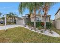 Two-story house with a landscaped yard, paver driveway and palm trees at 10405 White Peacock Pl, Riverview, FL 33578