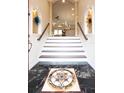 Elegant entryway with a grand staircase and marble flooring at 105 Wimbledon Ct, Redington Shores, FL 33708