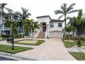 Two-story house with a red door, palm trees, and a brick driveway at 105 Wimbledon Ct, Redington Shores, FL 33708