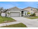 Two-story house with gray siding, two-car garage, and landscaped yard at 12152 Ledbury Commons Dr, Gibsonton, FL 33534