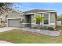 Two-story house with gray siding, two-car garage, and landscaped yard at 12152 Ledbury Commons Dr, Gibsonton, FL 33534